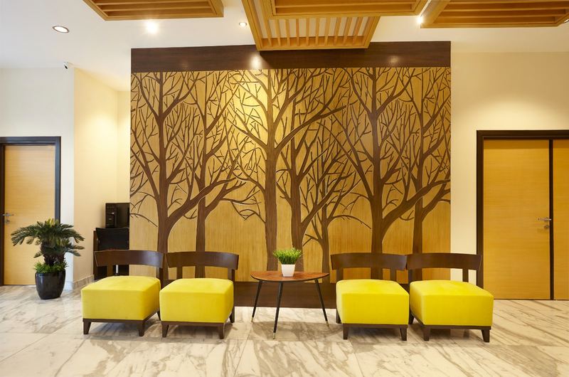 Yellow armchairs in front of the carved tree wall