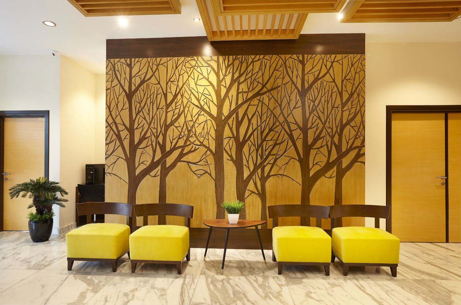 Yellow armchairs in front of the carved tree wall